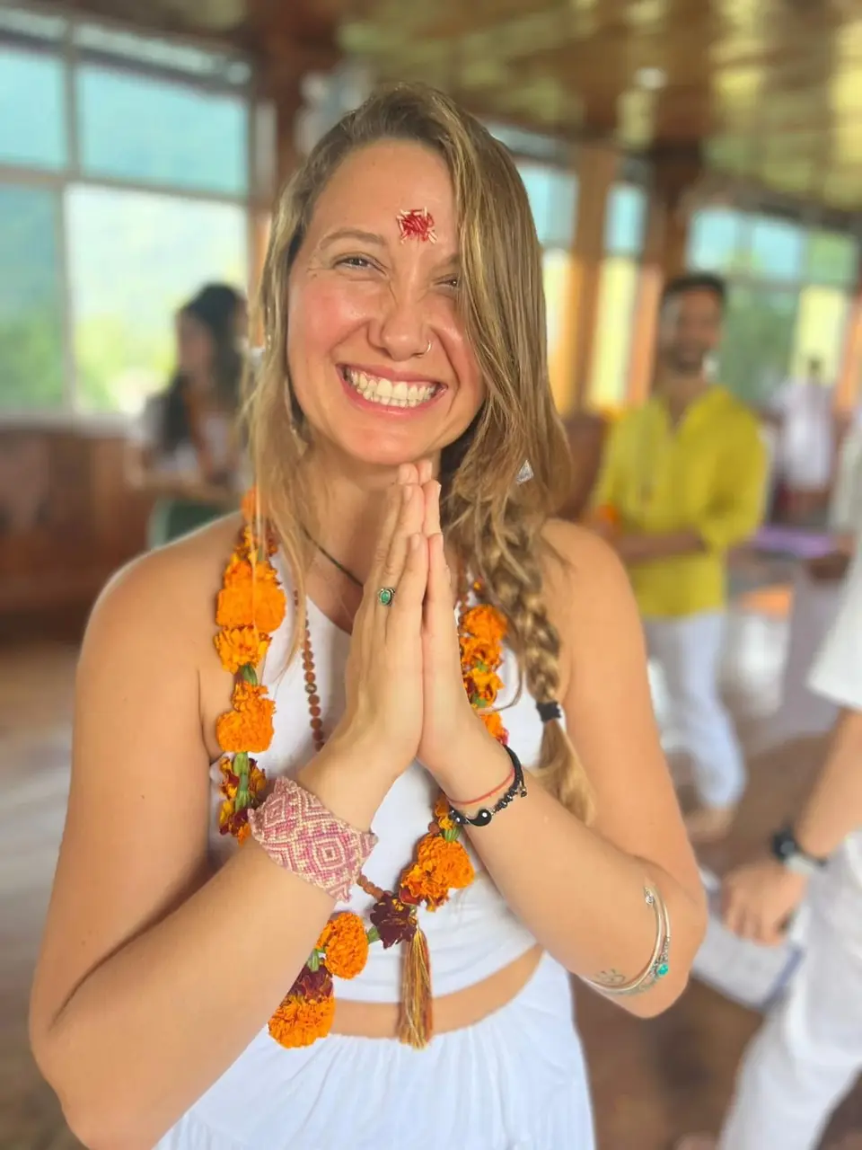 Antu el día de su graduación en Rishikesh, con guirnaldas de flores y las manos juntas